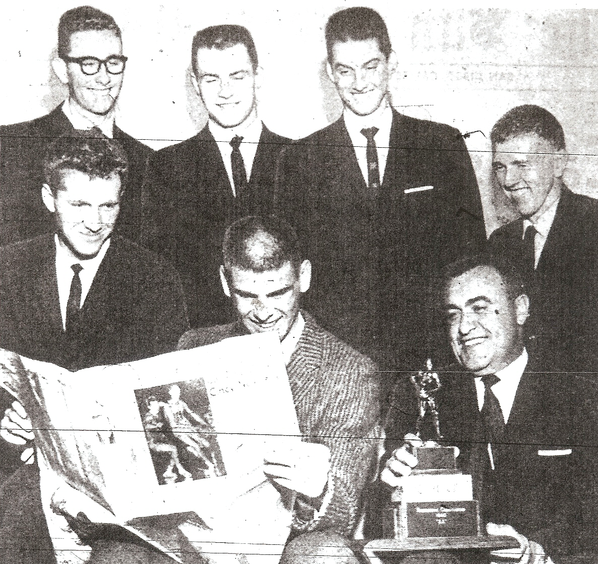 Winning Pointers, back row from left: Larry Moore, Mike Dolphin, Dick Walden, Doug Lawrence. Front: Winston Yetta, Don Sadas, reading newspaper account, and coach Hilbert Crosthwaite.