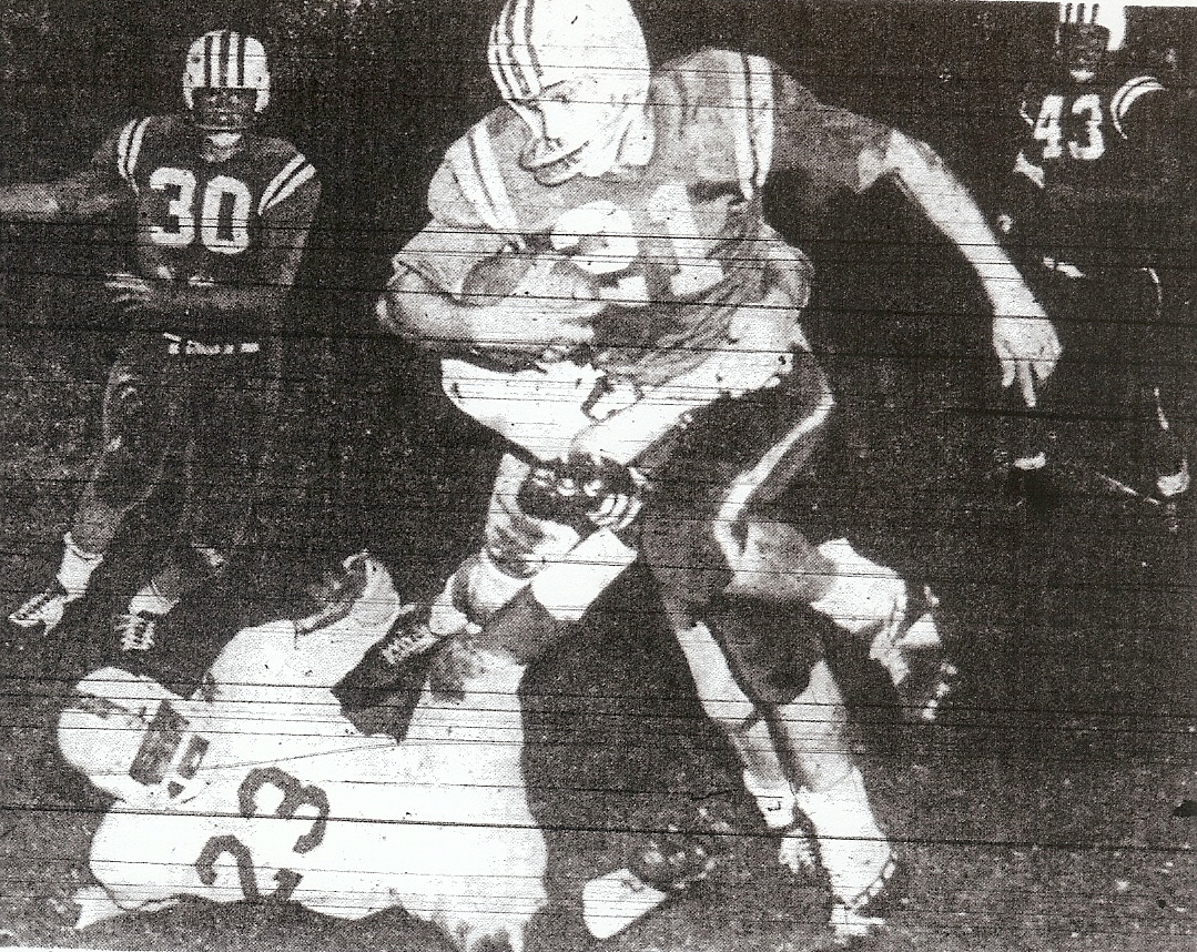 Crawford's Bill Rainey, all Southern California, is tackled by unidentified Kearny defender, while Don Henderson (23), Jimmy Gilbert (30), and Larry Guske (43) are witnesses. Colts won San Diego Section title.